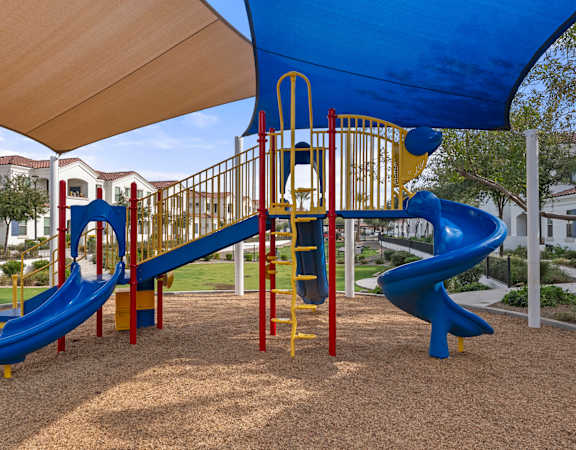 A playground with a blue slide and yellow ladder.