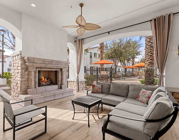 A patio with a fireplace and furniture.
