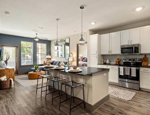 A modern kitchen with a large island and stainless steel appliances.
