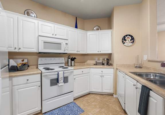 A kitchen with white cabinets and appliances.