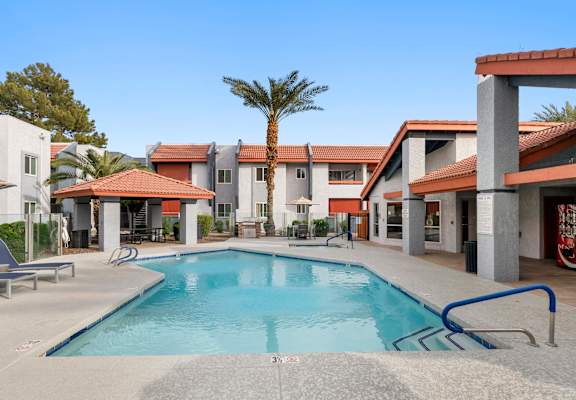 A pool in front of a building with a palm tree in the background.