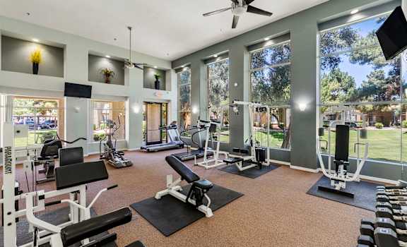 A spacious gym with a variety of equipment and a view of the outdoors.