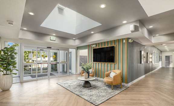 A modern office lobby with a striped wall and a flat screen TV.