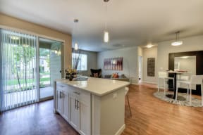 Kitchen with Bar Seating, Hardwood Inspired Floor, View of Patio and Dining Area