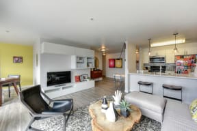 Living Room Kitchen and Dining Area with Hardwood Inspired Floor, Black Chair, Bar Seating and Black/White Rug