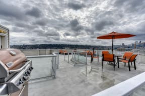 Rooftop BBQ and Picnic Area with Grill, Red Patio Umbrella and Chairs