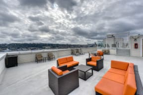 Rooftop Seating Area with Orange Chairs, Sofas and View of City