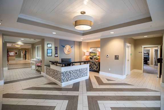 A reception area with a white reception desk and a patterned tile floor.