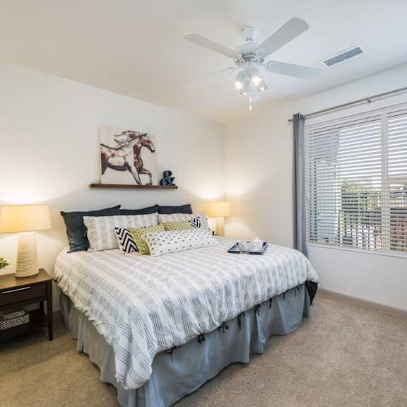 an open concept living room and dining area with a white dining table and rattan chairs at Arterra Place Apartments, Aurora, CO, 80017
