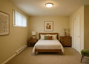 Thumbnail 3 of 8 - A bedroom with a bed, nightstands, and a chair.