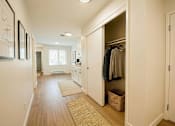 Thumbnail 1 of 8 - A hallway with a white door and a brown rug.