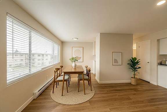 A dining room with a table and chairs.