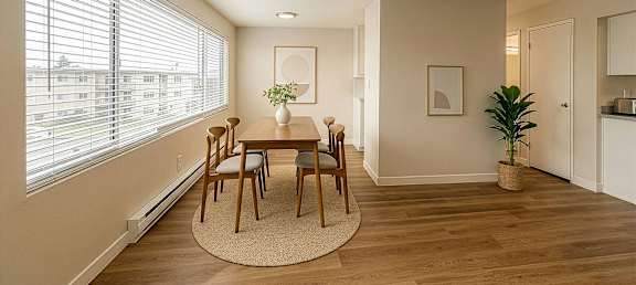 A dining room with a table and chairs.