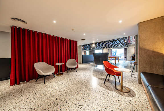 A room with red curtains and a red chair.