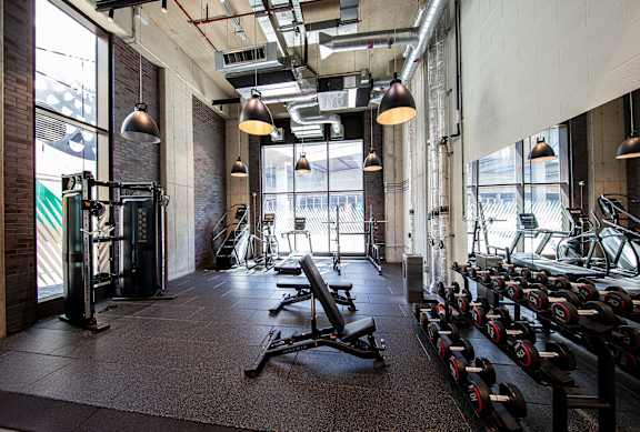 A gym with a variety of equipment including weights and machines.