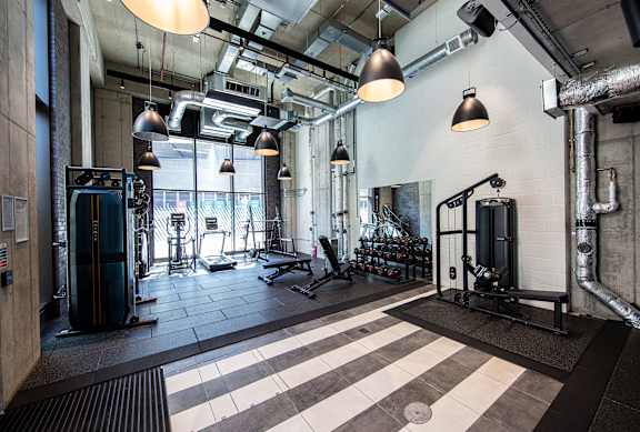 A gym with a variety of equipment including weights and machines.