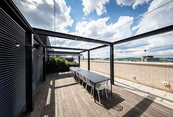A table and chairs are set up on a wooden deck.