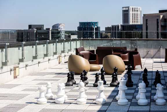 A giant chess set is set up on a rooftop.