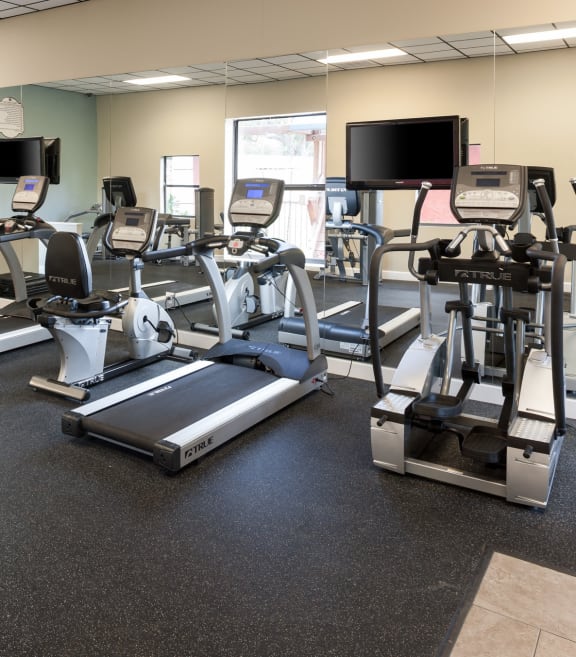 a gym with various exercise equipment on the floor