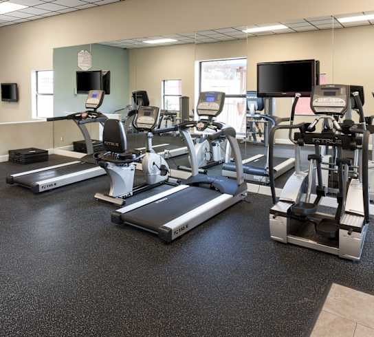 a gym with various exercise equipment on the floor