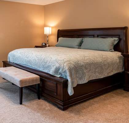 Bedroom with plush carpeting, model furnishings, and bedside lamps