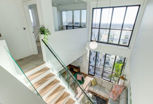 a view of the living room from the top of the stairs in a modern home