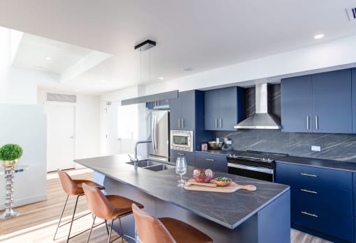 a kitchen with blue cabinets and a marble counter top