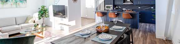 a living room and dining room with a table and chairs