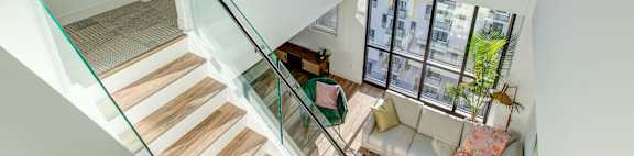 a view of the living room from the top of the stairs in a modern home