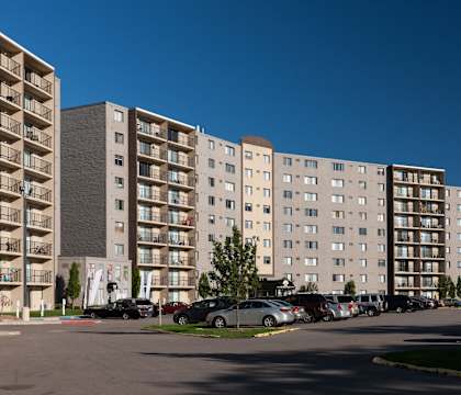 a large apartment building with cars parked in front of it