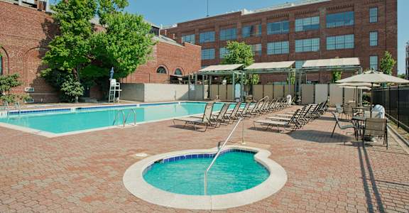 a swimming pool with chaise lounge chairs in front of a buildingat Tindeco Wharf, Baltimore Maryland