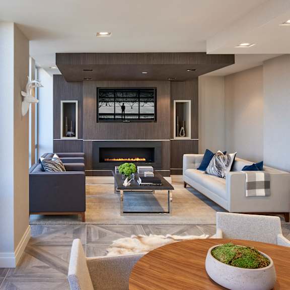 A modern living room with a fireplace and a large painting on the wall.