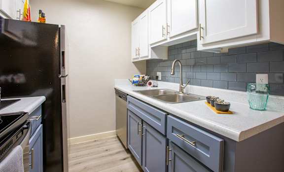 a kitchen with blue cabinets and a sink and a refrigerator