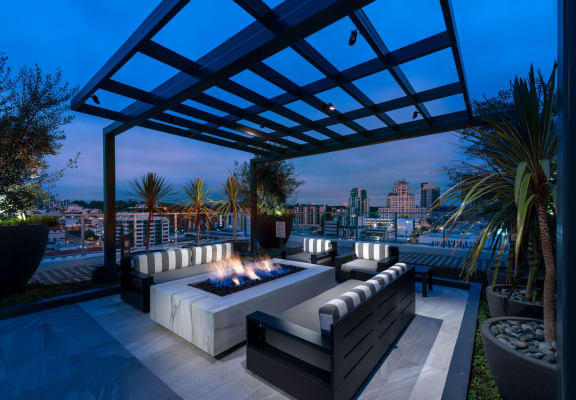 a patio with a firepit and a view of the city