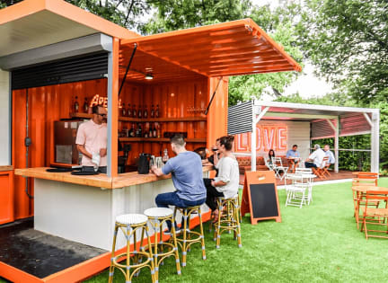a bar with people sitting at it on the grass