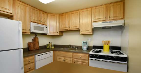 a kitchen with white appliances and wooden cabinets