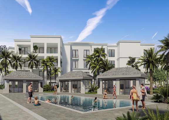 A group of people are enjoying a sunny day by a pool in front of a large white building.