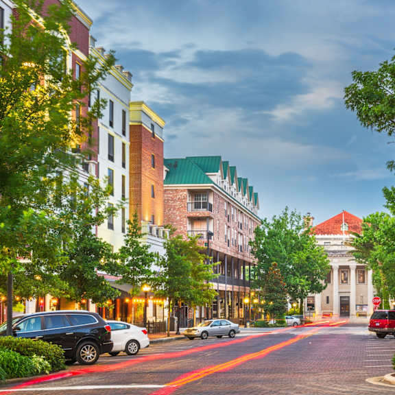 A street view of a city with cars parked on the side of the road.