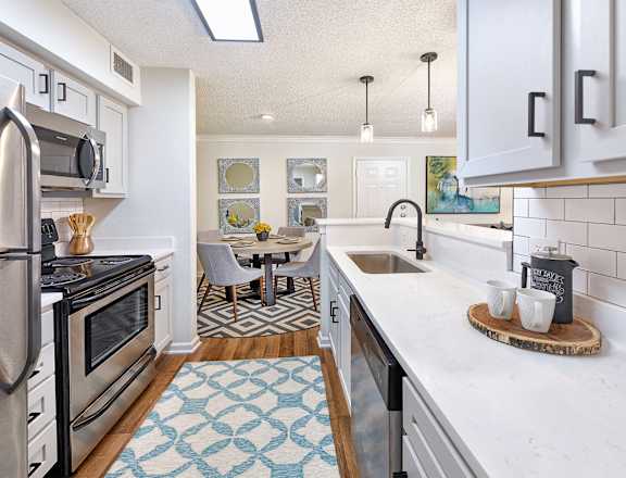 A kitchen with a refrigerator, microwave, and oven.
