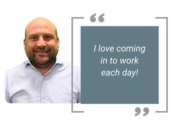 A man with a shirt and a quote box saying "I love coming in to work each day!"