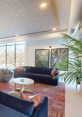 a living room with couches and chairs and a dining room with a table