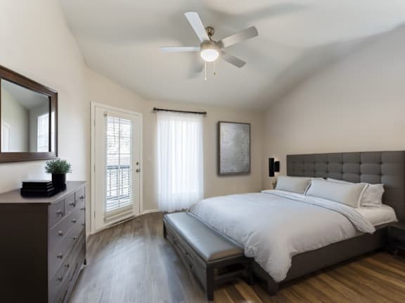 A bedroom with a bed, dresser, and mirror.