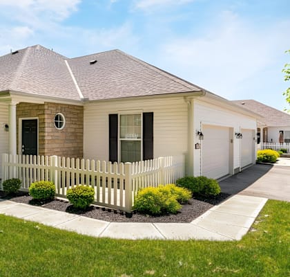A house with a white picket fence in front.