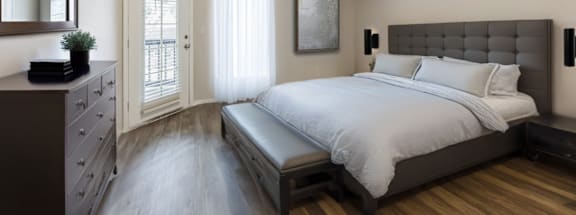 A bedroom with a bed, dresser, and mirror.