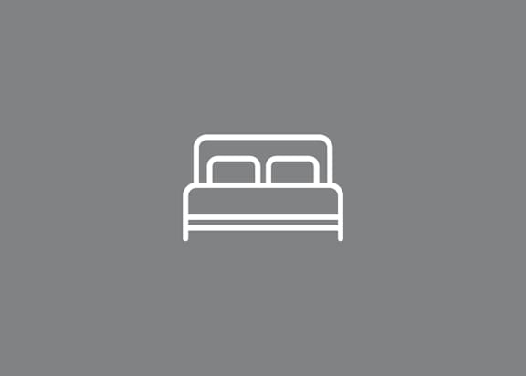 A simple line drawing of a bed with a pillow.