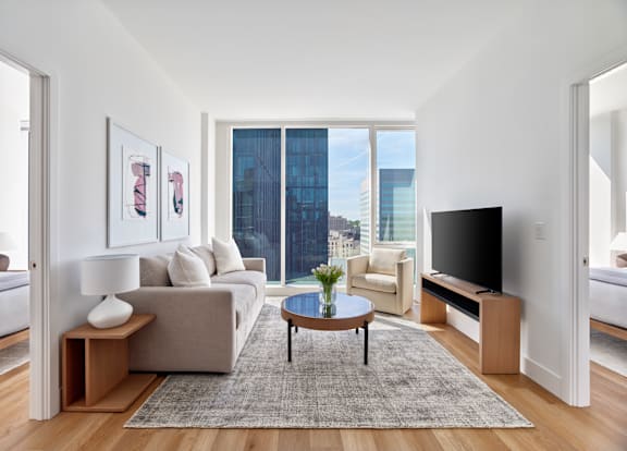 A living room with a couch, a coffee table, and a television.