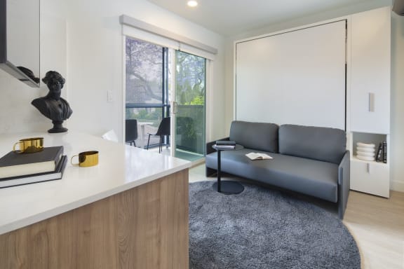 a living room with a gray couch and a white counter top
