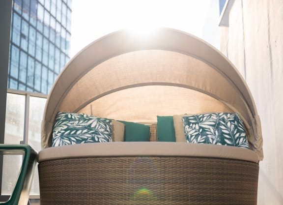 a large couch with green pillows in front of a large window