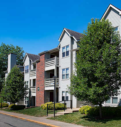 Apartment building with a tree in front of it.