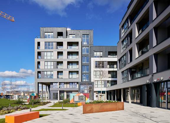 a view of a courtyard between two modern apartment buildings